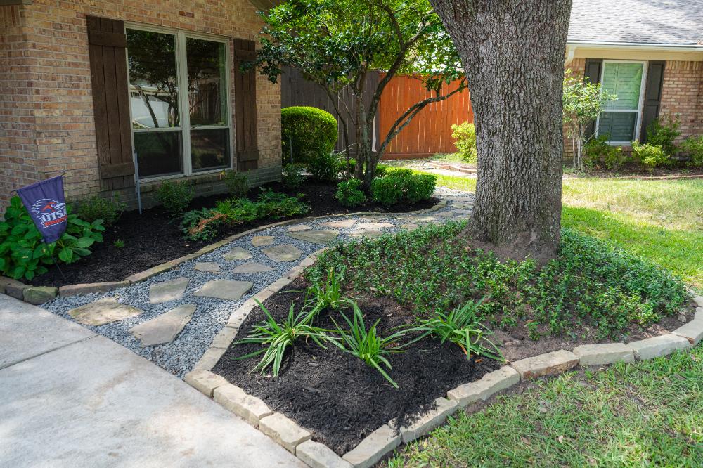 Newsly installed stone walkway and garden bed around a tree at a residential home