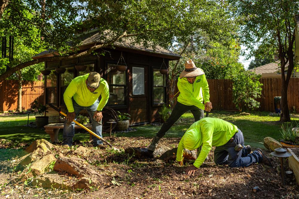 Freshly mowed front yard with lush grass and trimmed plants in Hunter Creek Village, TX