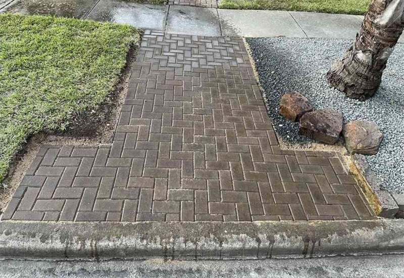 Brick walkway with trimmed grass in Houston, TX