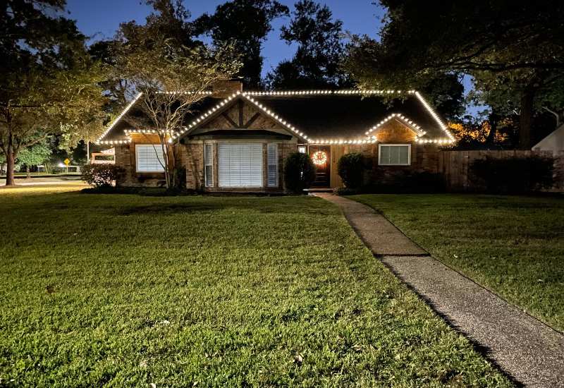 Beautifully decorated residential property with bright Christmas lights in Houston, TX