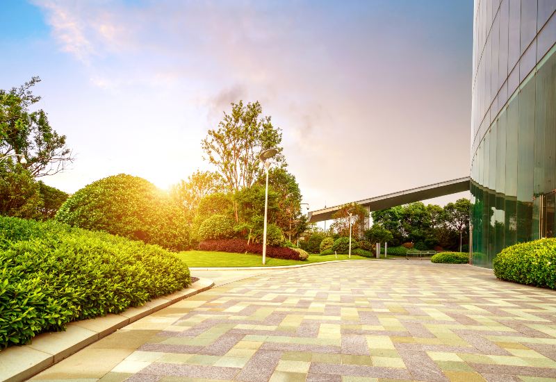 Commercial landscape designed with decorative shrubs and a paved pathway in Houston, TX