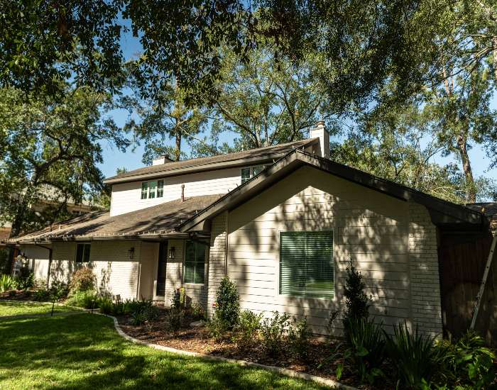 Front yard landscaping showcasing a mowed lawn, shrubs, and trees in The Woodlands, TX