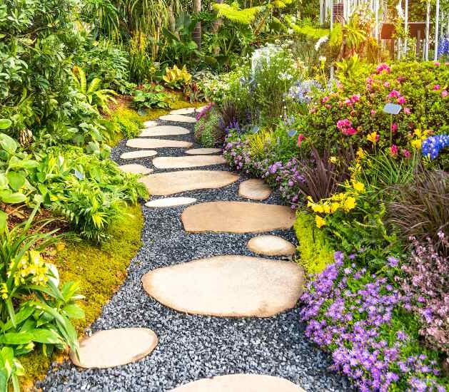 Beautifully designed residential property with mixed flowers and a gravel stone pathway in Houston