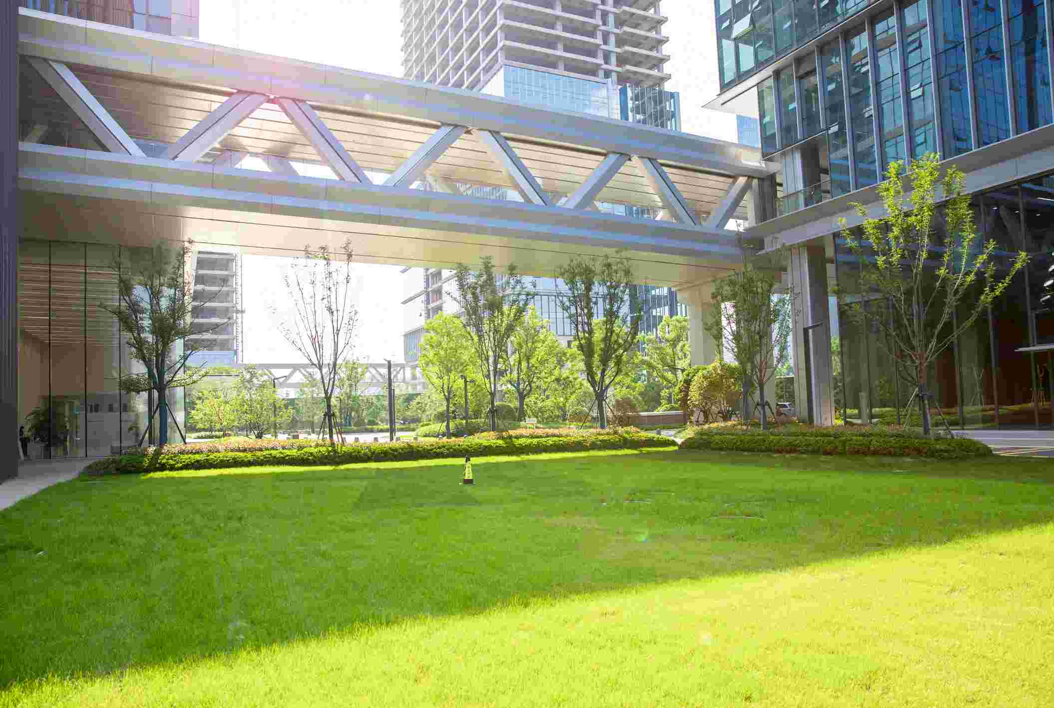 Modern office courtyard with skybridge and green lawn in Houston, TX