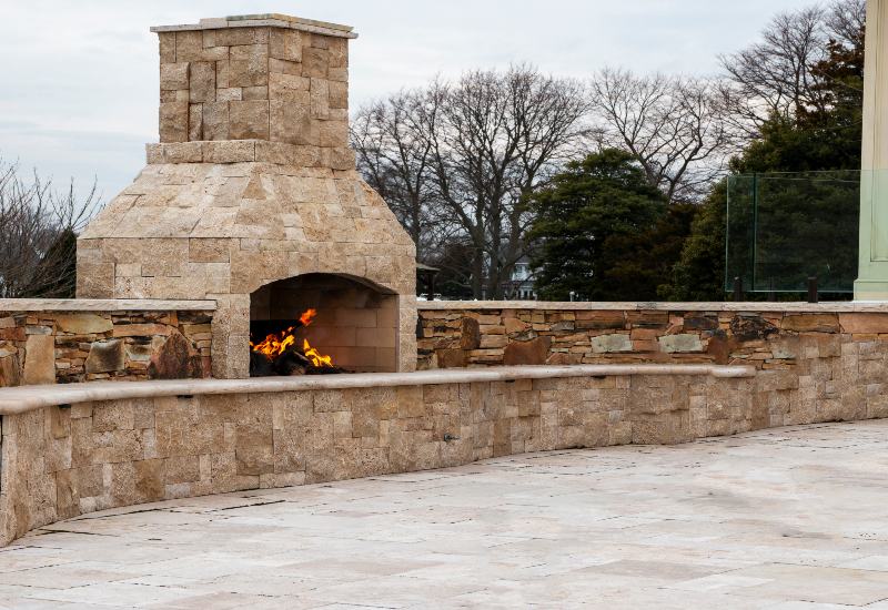 Large outdoor fireplace built with natural stone in Houston, TX