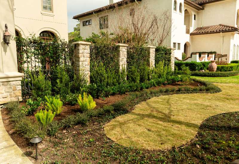 Decorative stone pillars installed in a landscaped garden in Houston, TX