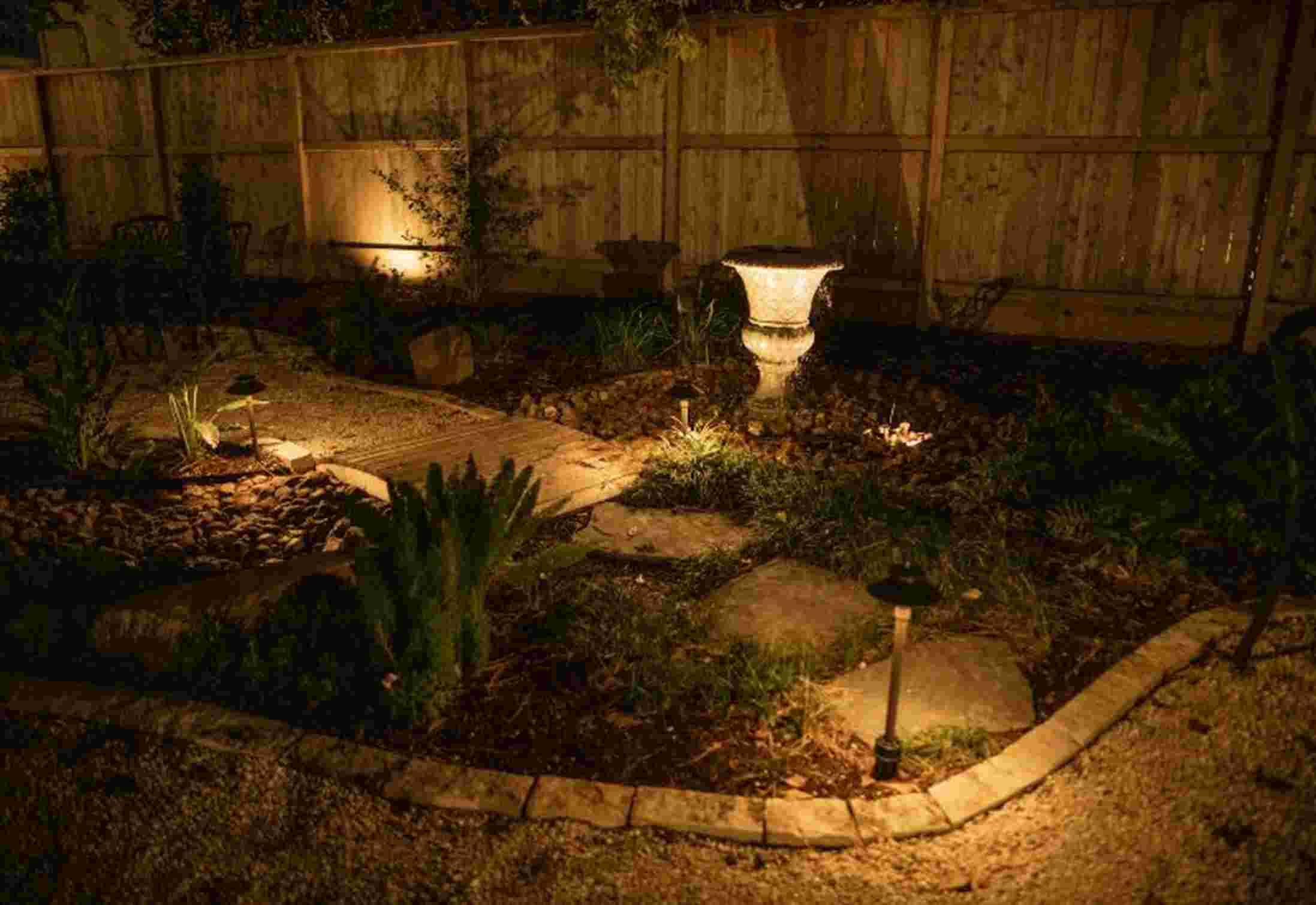 Night garden path with stone features and soft lighting in Houston, TX