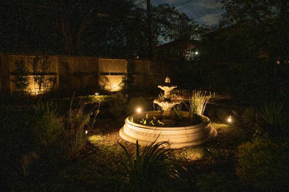 Illuminated garden fountain with landscape lighting in Houston, TX